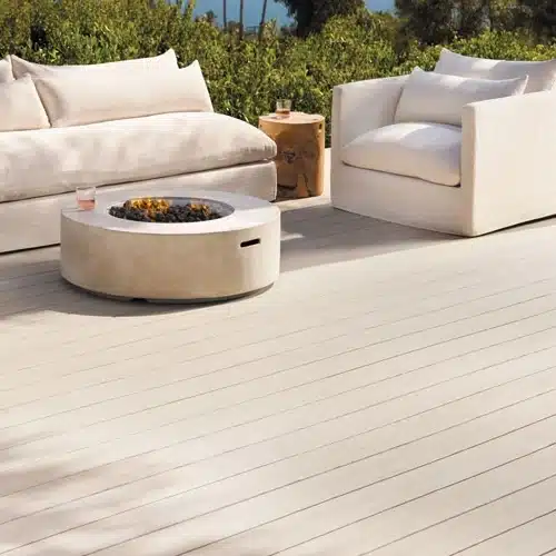 pvc-decking-with-outdoor-living-sofa-and-firepit-with-glass-bottle-of-drink-surrounded-by-grass-in-the-background-in-south-east-pa