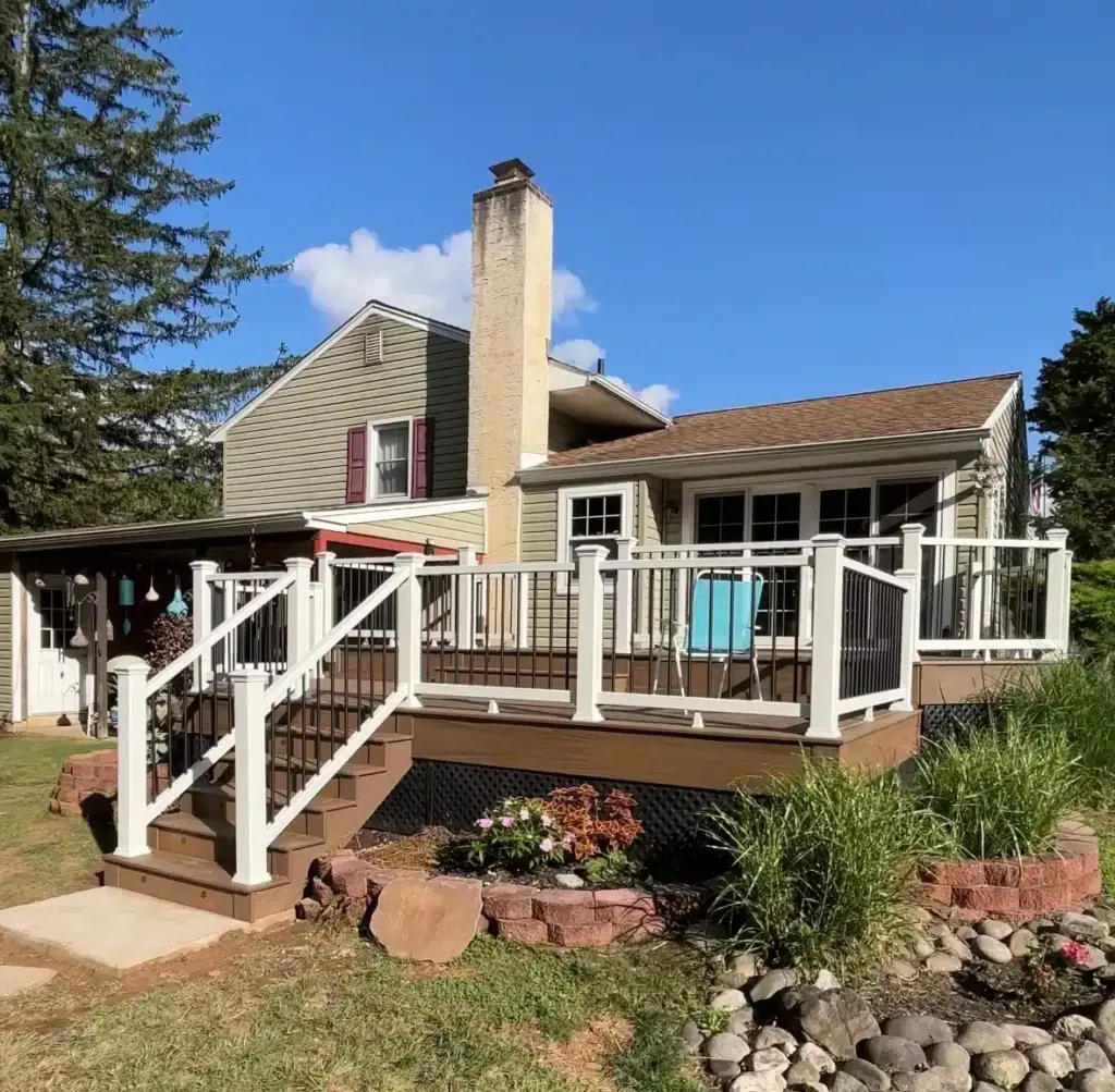 raised-residential-deck-with-black-balusters-and-white-railing-on-the-mocha-house-with-outdoor-blue-chair-surrounded-by-plants-and-stones-featuring-sky-blue-view-in-south-east-pa